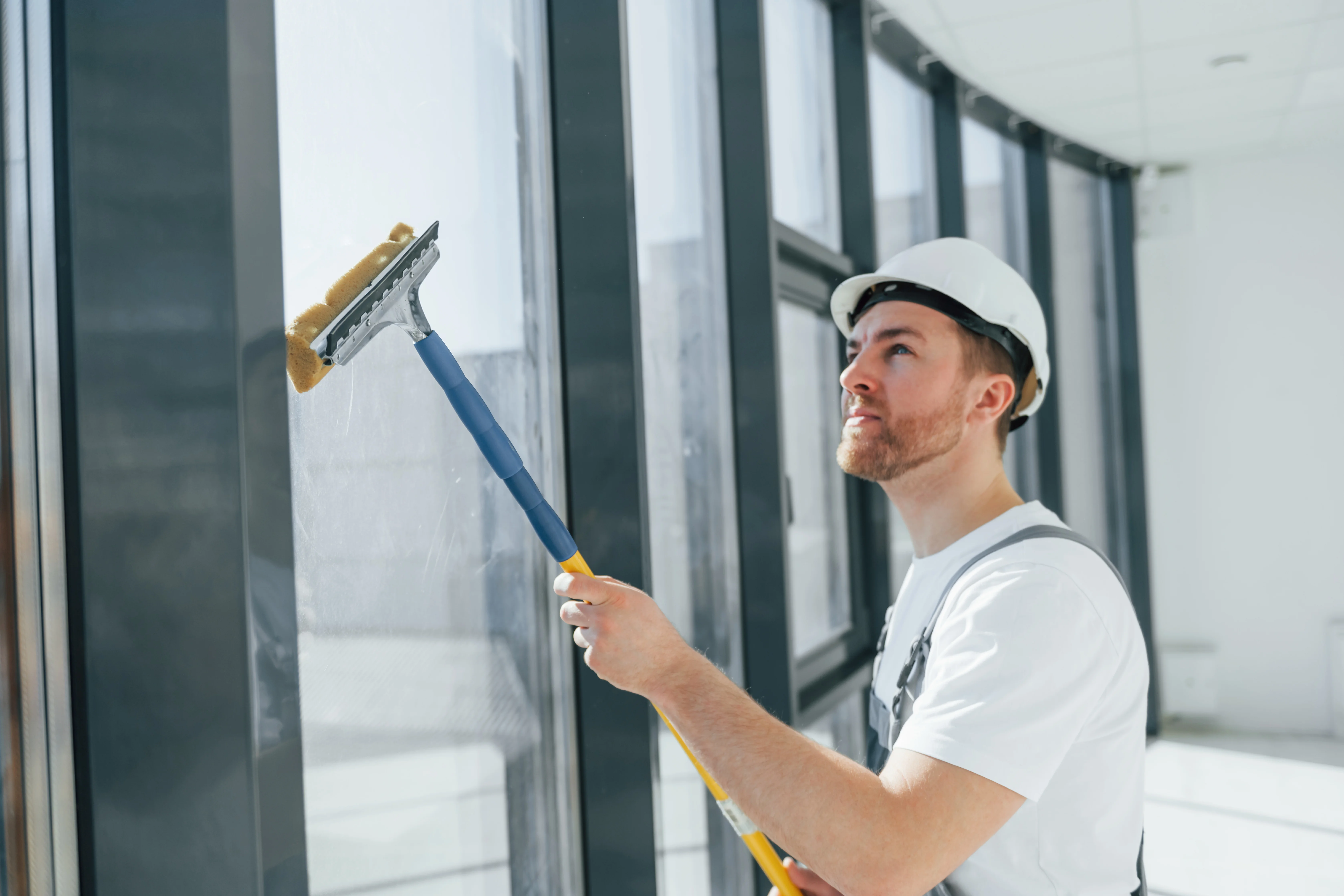 Professional cleaning interior windows after construction to remove dust and residue